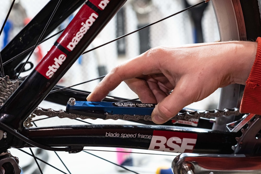 a person holding a bike chain with their hand