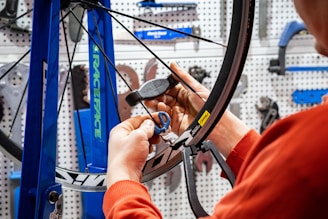 a man working on a bicycle wheel in a shop
