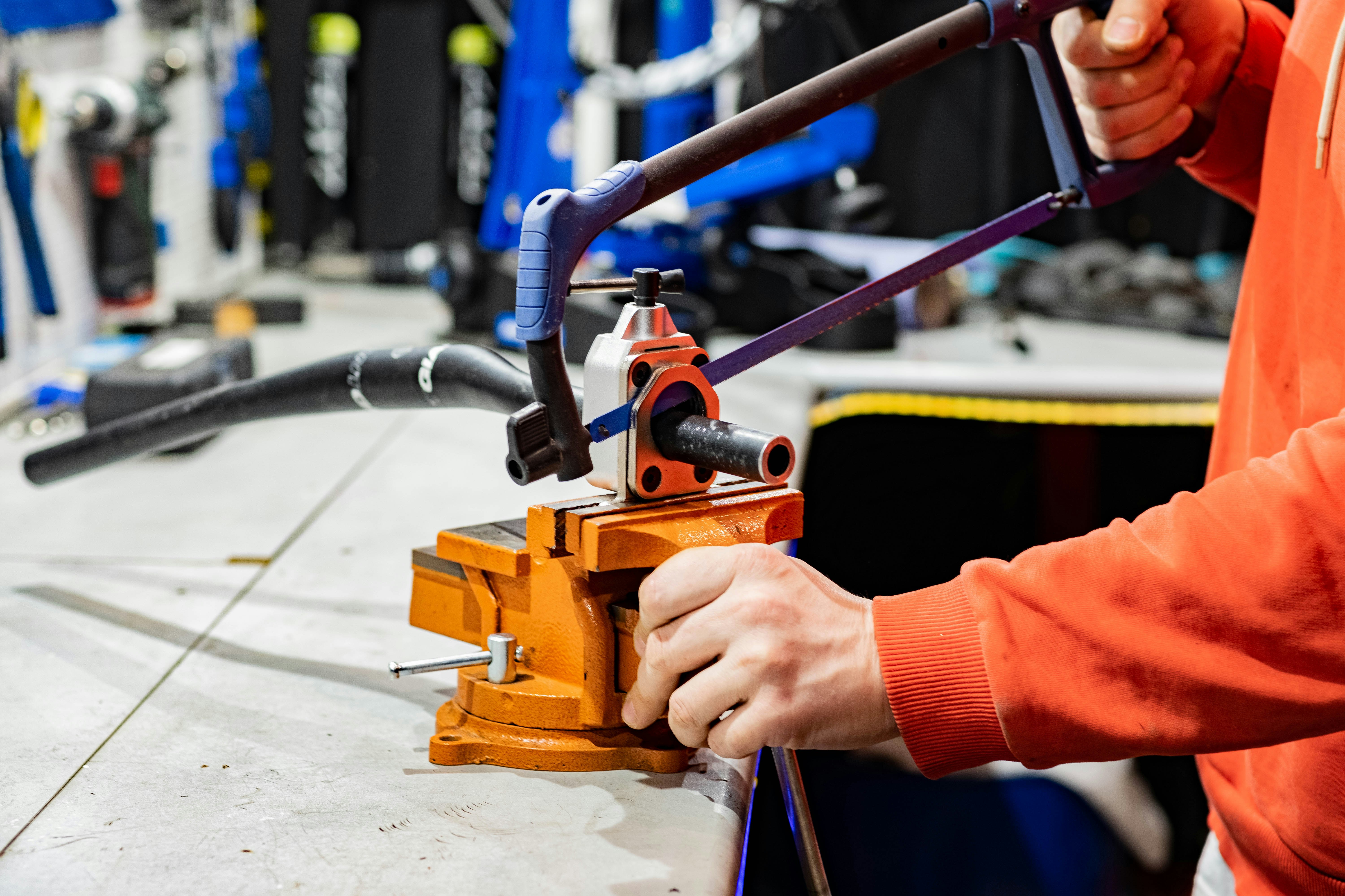 Mechanic in protective gear working on high‑voltage orange cables in an electric car