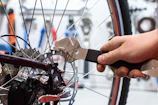 Technician’s hands fine-tuning a delicate brake cable with precision tools.