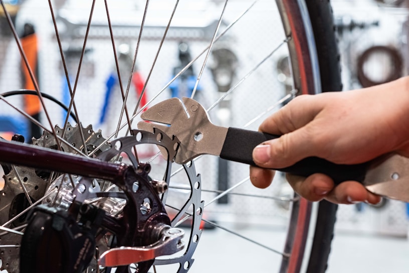 a person is holding a wrench and working on a bicycle wheel