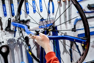 a person working on a bicycle wheel in a garage
