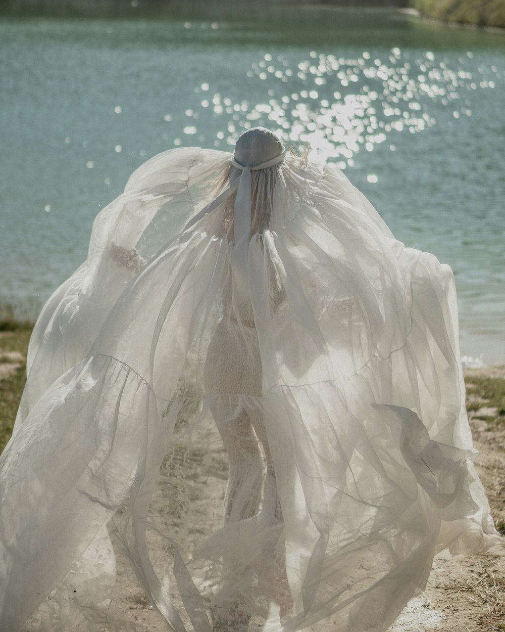 a woman in a white dress standing on a beach