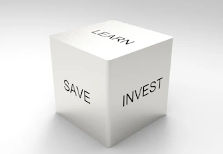 A three-dimensional cube with words on its visible sides, featuring 'LEARN' on the top, 'SAVE' on the left face, and 'INVEST' on the right face. The cube is rendered in a minimalist white and gray color palette, creating a clean and professional look.