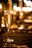 Elegant close-up of a hand pouring Valdobbiadene prosecco into a crystal flute at a dimly lit table.