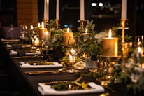 A luxurious private dining setup in a rice field with candles and elegant tableware.