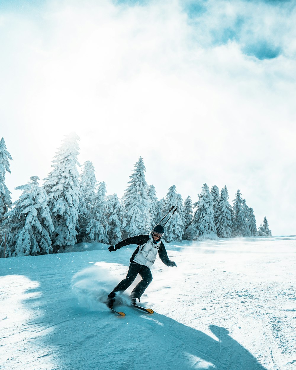 a man riding skis down a snow covered slope