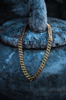 a gold chain sitting on top of a rock