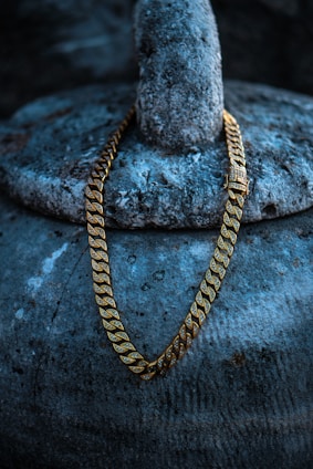 a gold chain sitting on top of a rock