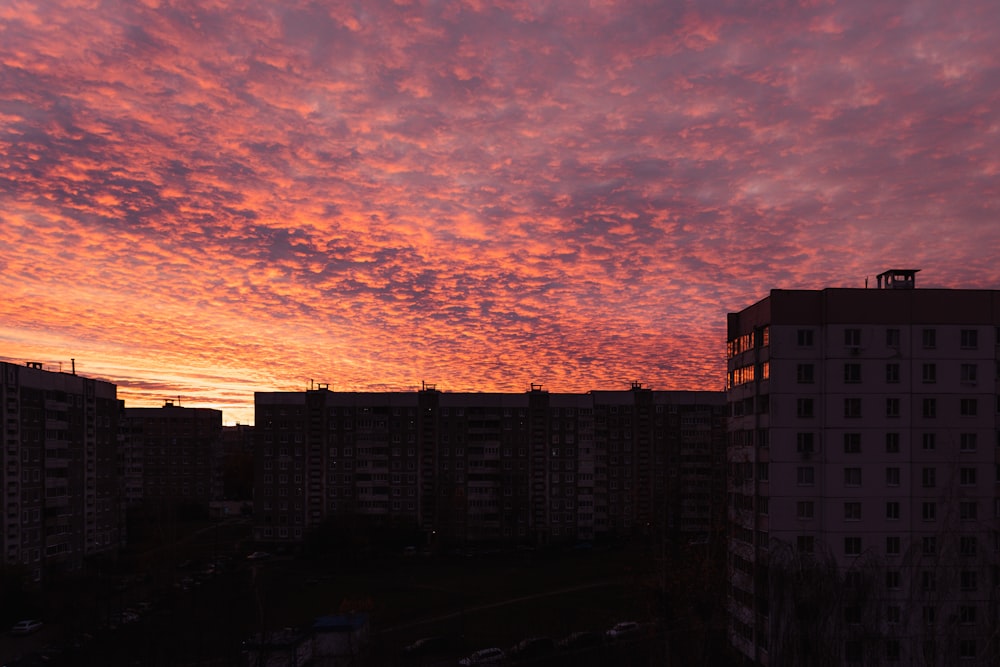 a sunset view of a city with tall buildings