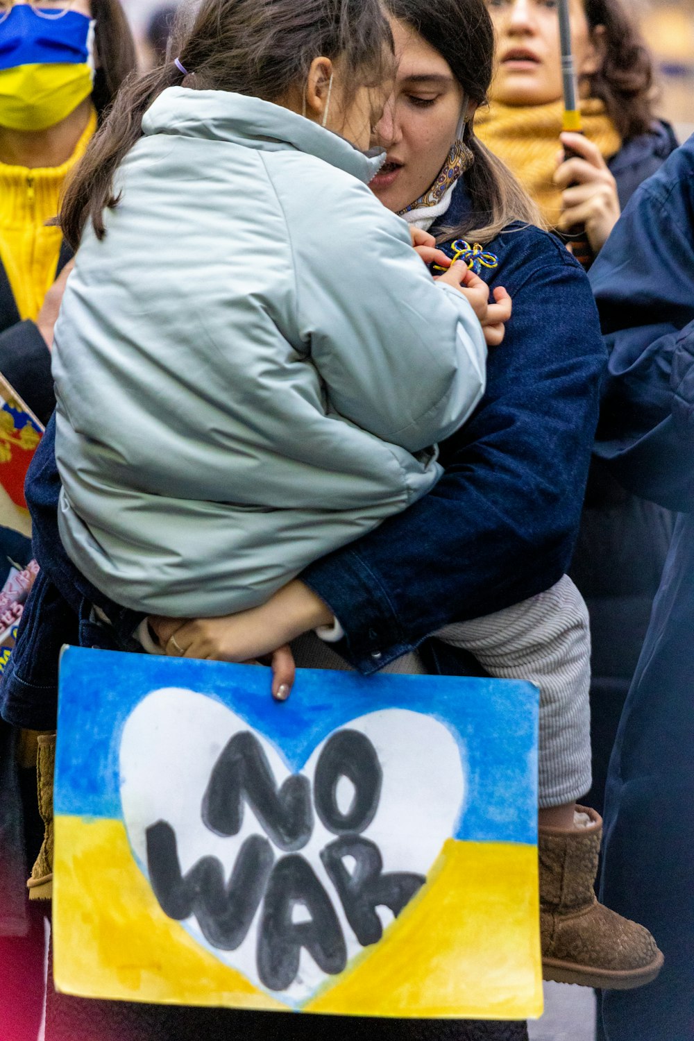 a woman hugging a child in front of a crowd of people