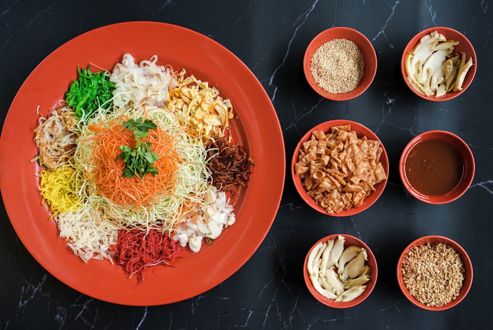 a red plate topped with lots of different types of food