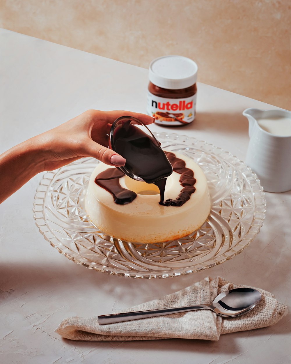 a person decorating a cake with chocolate icing