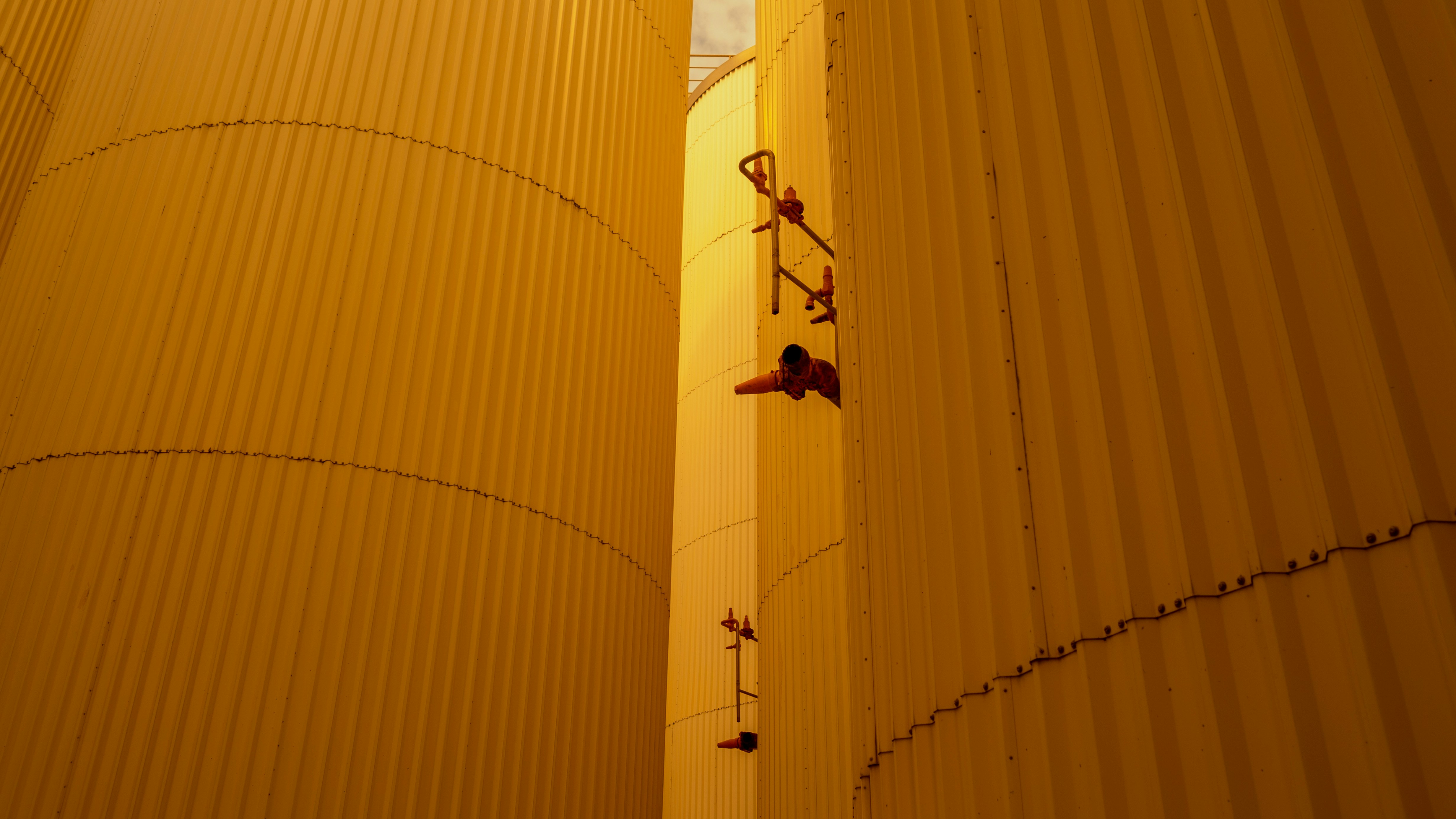 a man climbing up the side of a yellow building