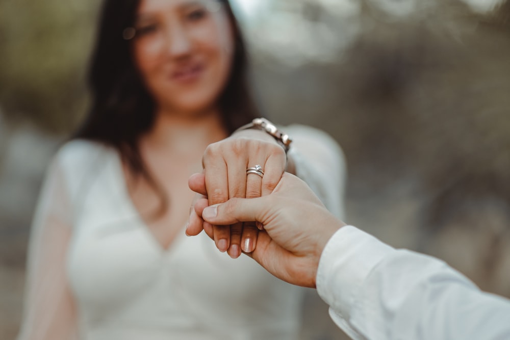 a woman holding the hand of a man