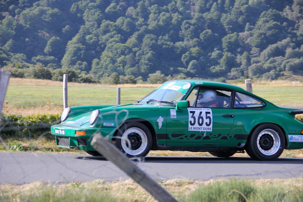 um carro esportivo verde dirigindo por uma estrada rural