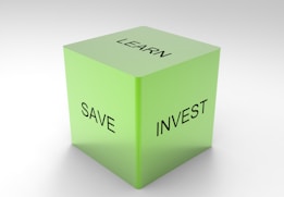 A green 3D cube with the words 'LEARN', 'SAVE', and 'INVEST' on its visible sides, set against a plain white background.