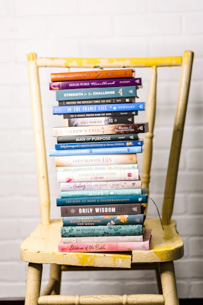 Stack of colorful evangelical books on a wooden table.