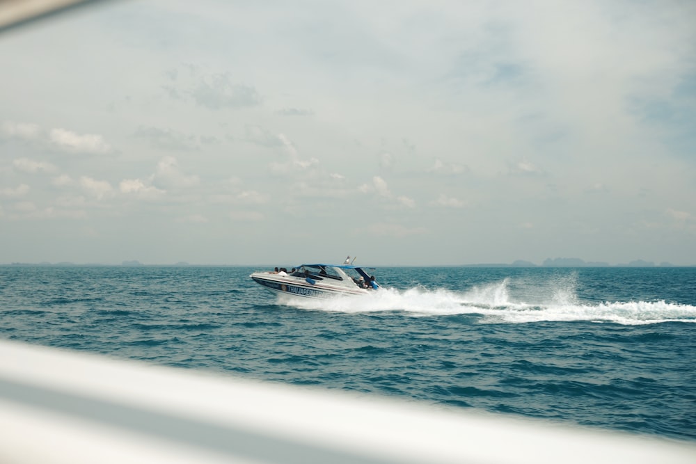 a speed boat speeding across the ocean on a sunny day