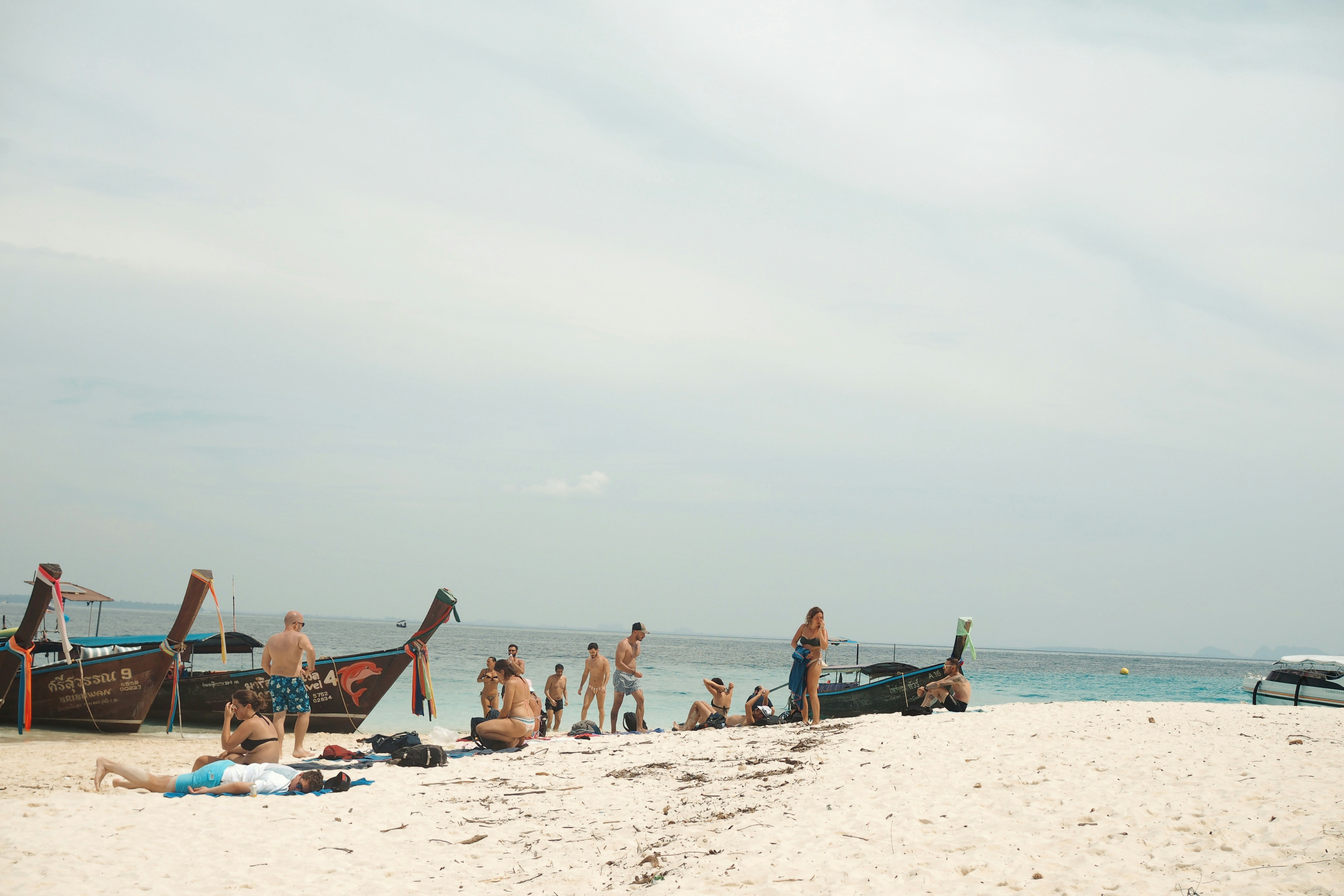 a group of people standing on top of a sandy beach