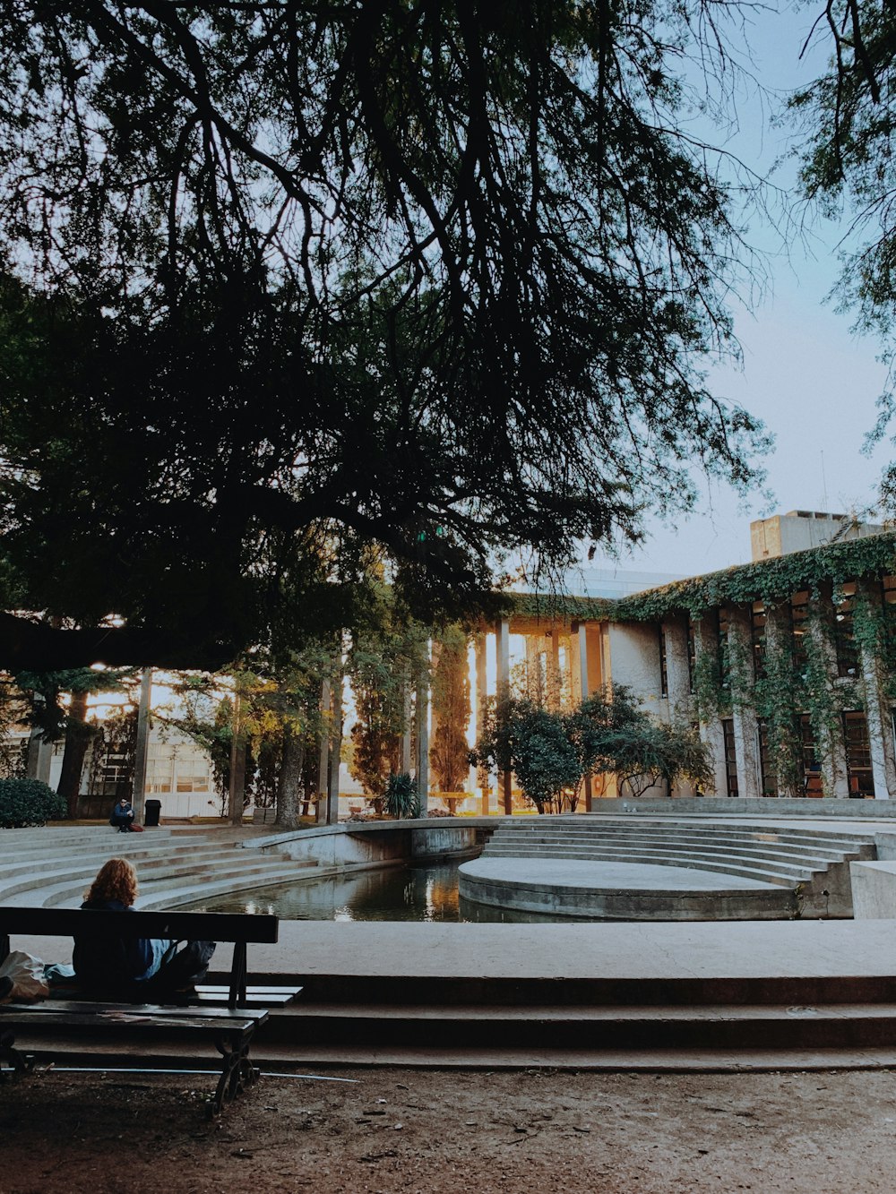 a woman sitting on a bench in front of a building