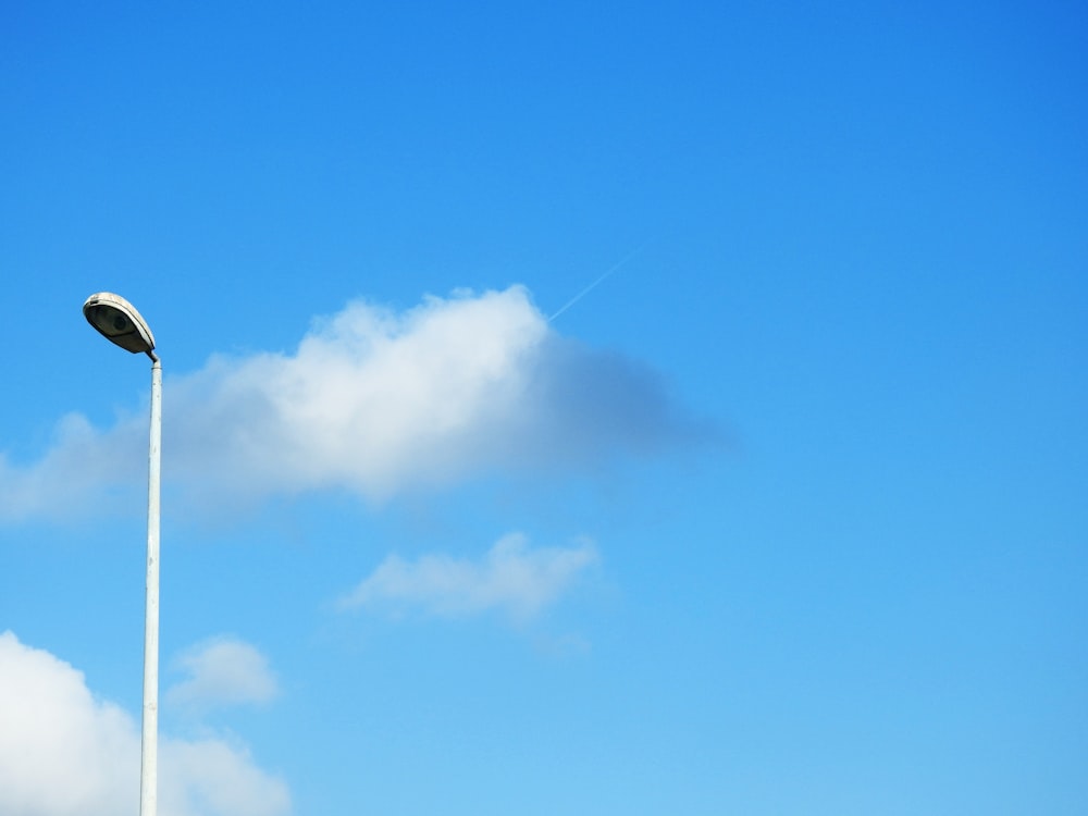 a street light in the middle of a cloud filled sky