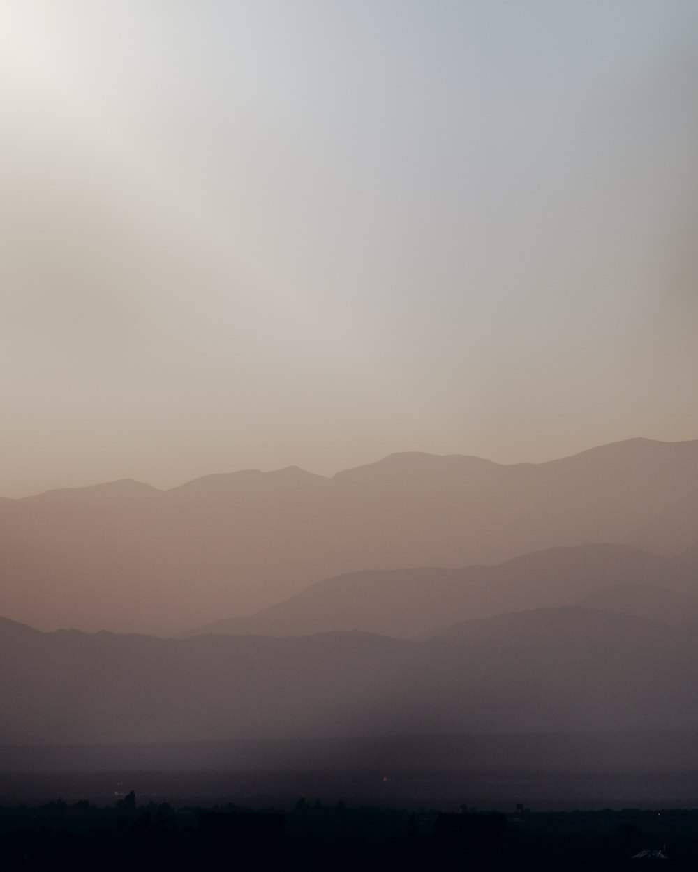 a plane flying in the sky with mountains in the background