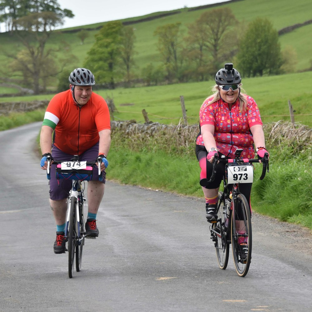 a couple of people riding bikes down a road