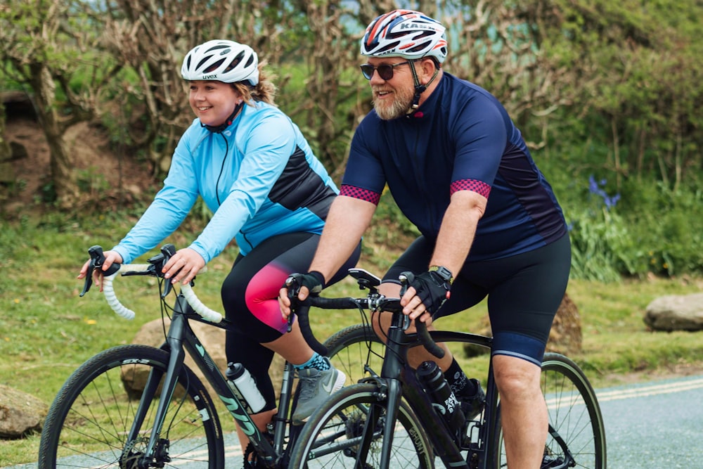 a couple of people riding bikes down a road