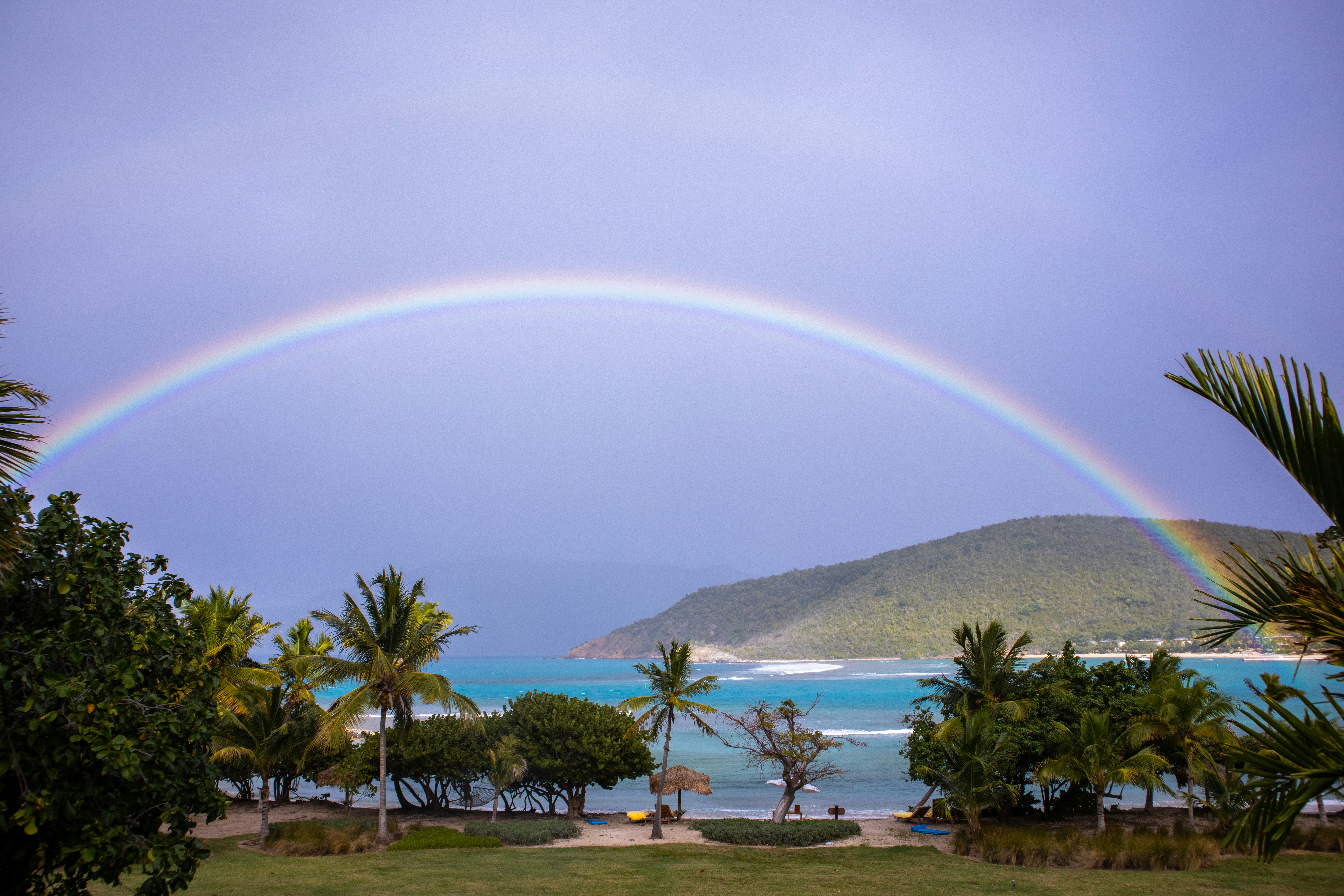 Ein doppelter Regenbogen am Himmel über einem Strand