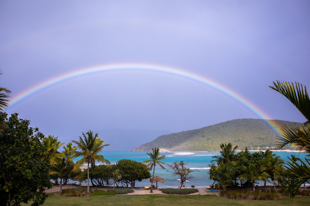 a double rainbow in the sky over a beach