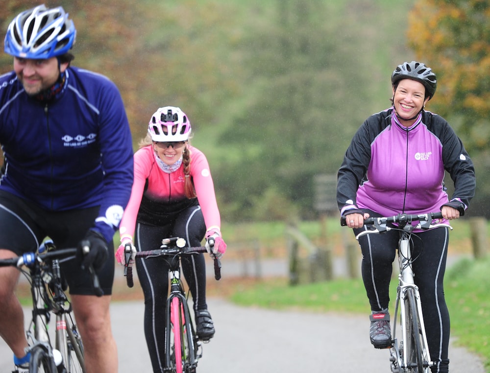 a couple of people riding bikes down a road