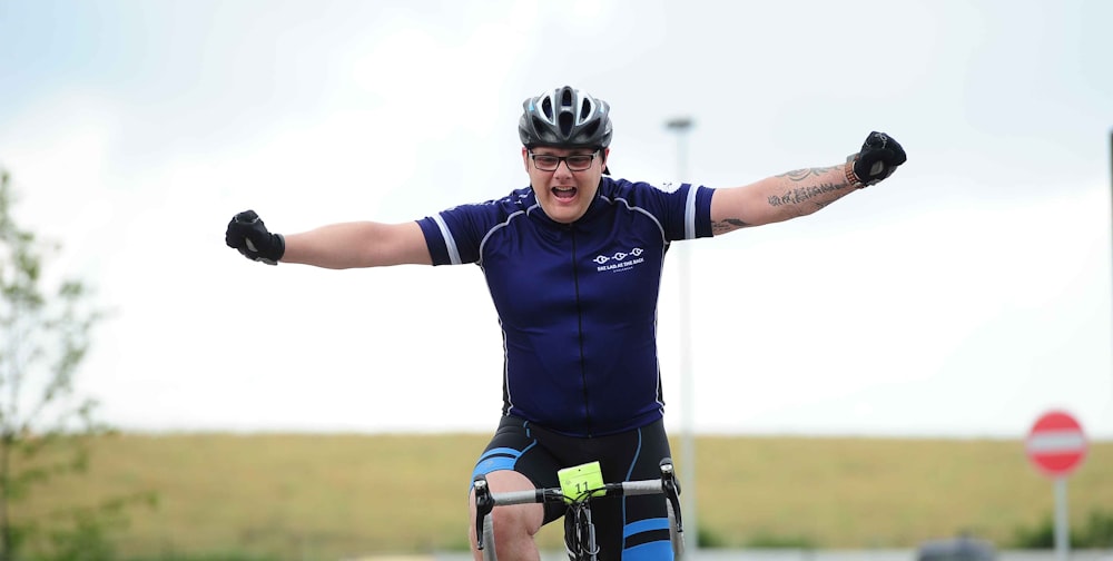 a man riding a bike with his arms outstretched