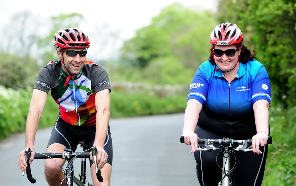 a man and a woman riding bikes down a road