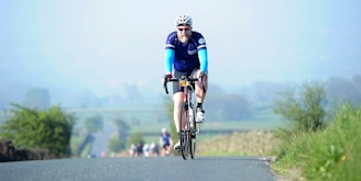 A cyclist racing through a scenic route in the French countryside during a championship event.