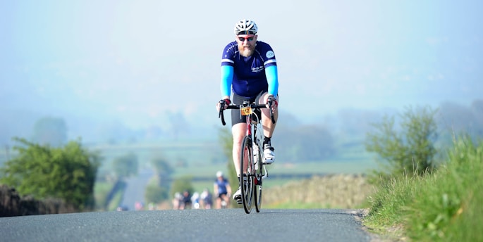 A cyclist racing through a scenic route in the French countryside during a championship event.
