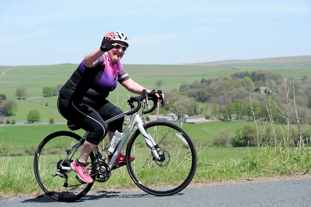 a woman riding a bike down a rural road