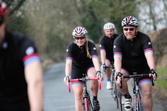 A group of cyclists wearing matching sponsored jerseys on a trail