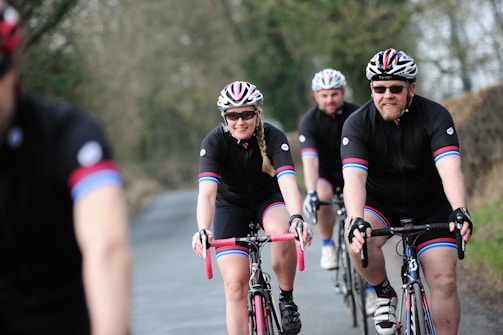 A group of cyclists wearing matching sponsored jerseys on a trail