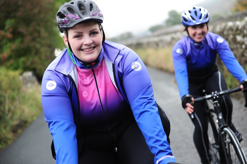 a couple of women riding bikes down a road