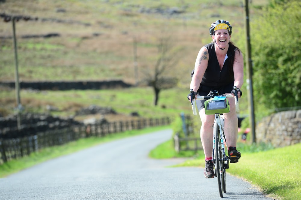 a woman riding a bike down a country road