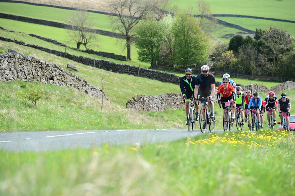 a group of people riding bikes down a road