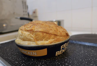 A rustic homemade meat pie fresh out of the oven with steam rising