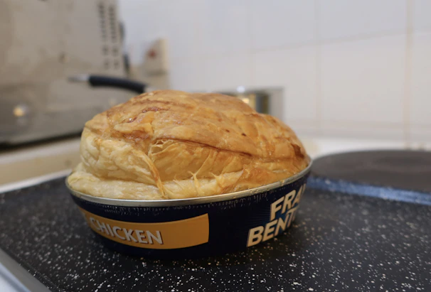 A rustic homemade meat pie fresh out of the oven with steam rising