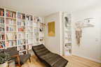 A gallery wall with minimalist framed prints and abstract art in a cozy reading nook.