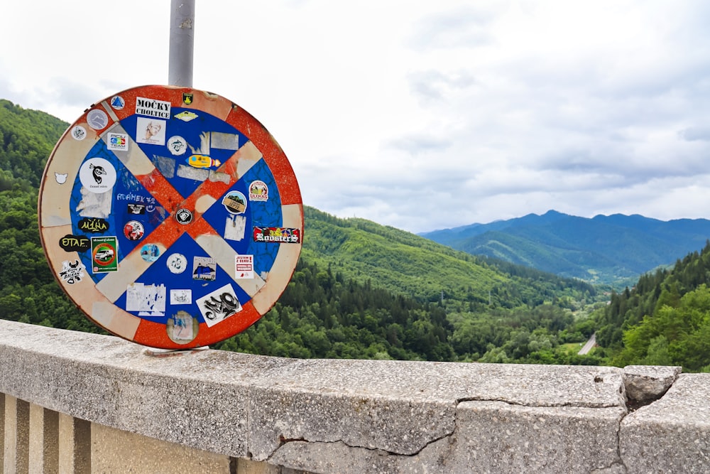 a colorful clock sitting on top of a stone wall