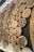 A collection of intricately carved wooden discs displayed on a dark background. The discs feature various patterns, symbols, and figures, including geometric designs, floral motifs, human figures, and animals. The carvings are detailed and showcase a range of artistic styles.