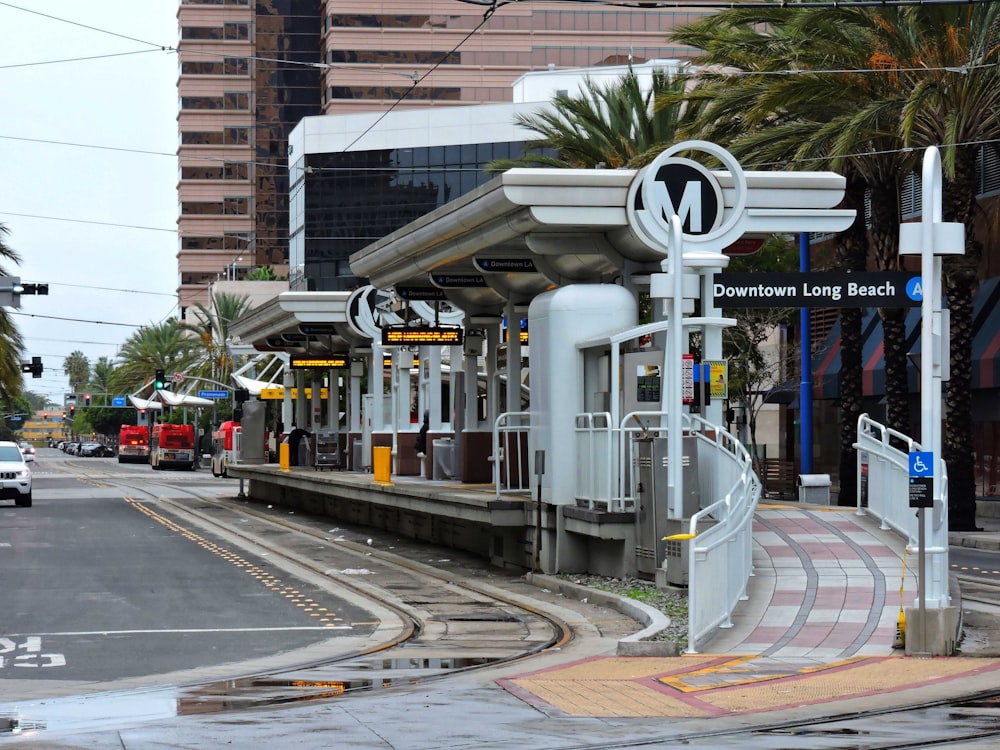 a train station on a city street with palm trees