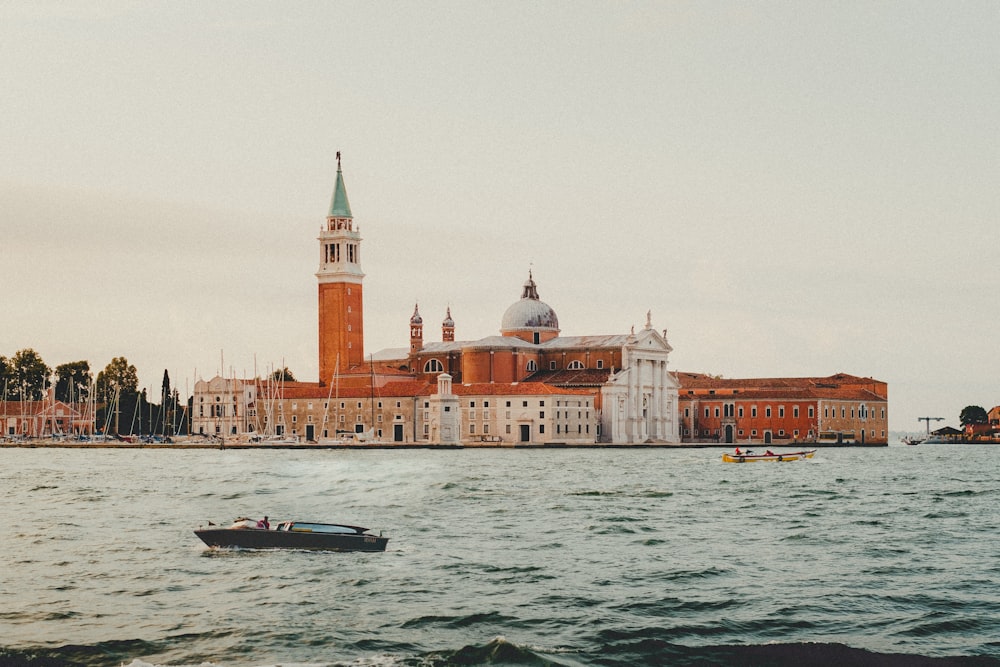 a boat in a body of water near a large building