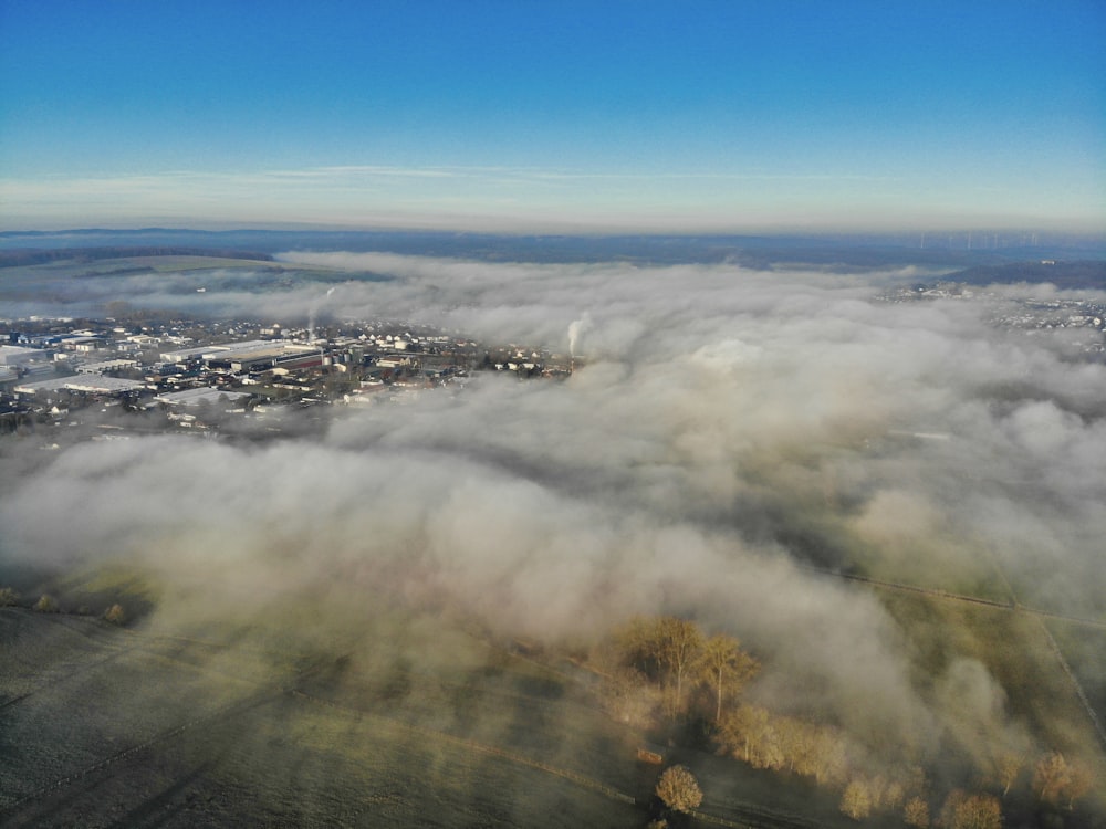an aerial view of a city surrounded by clouds